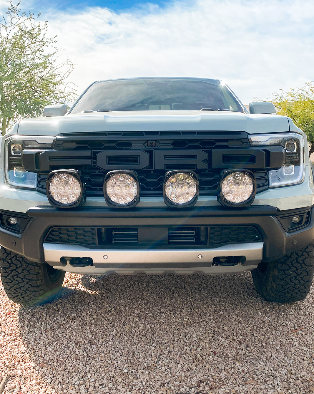 2024 Ranger Raptor Front Light Mount Kit installed on a stock bumper, featuring four mounted off-road lights for enhanced visibility.