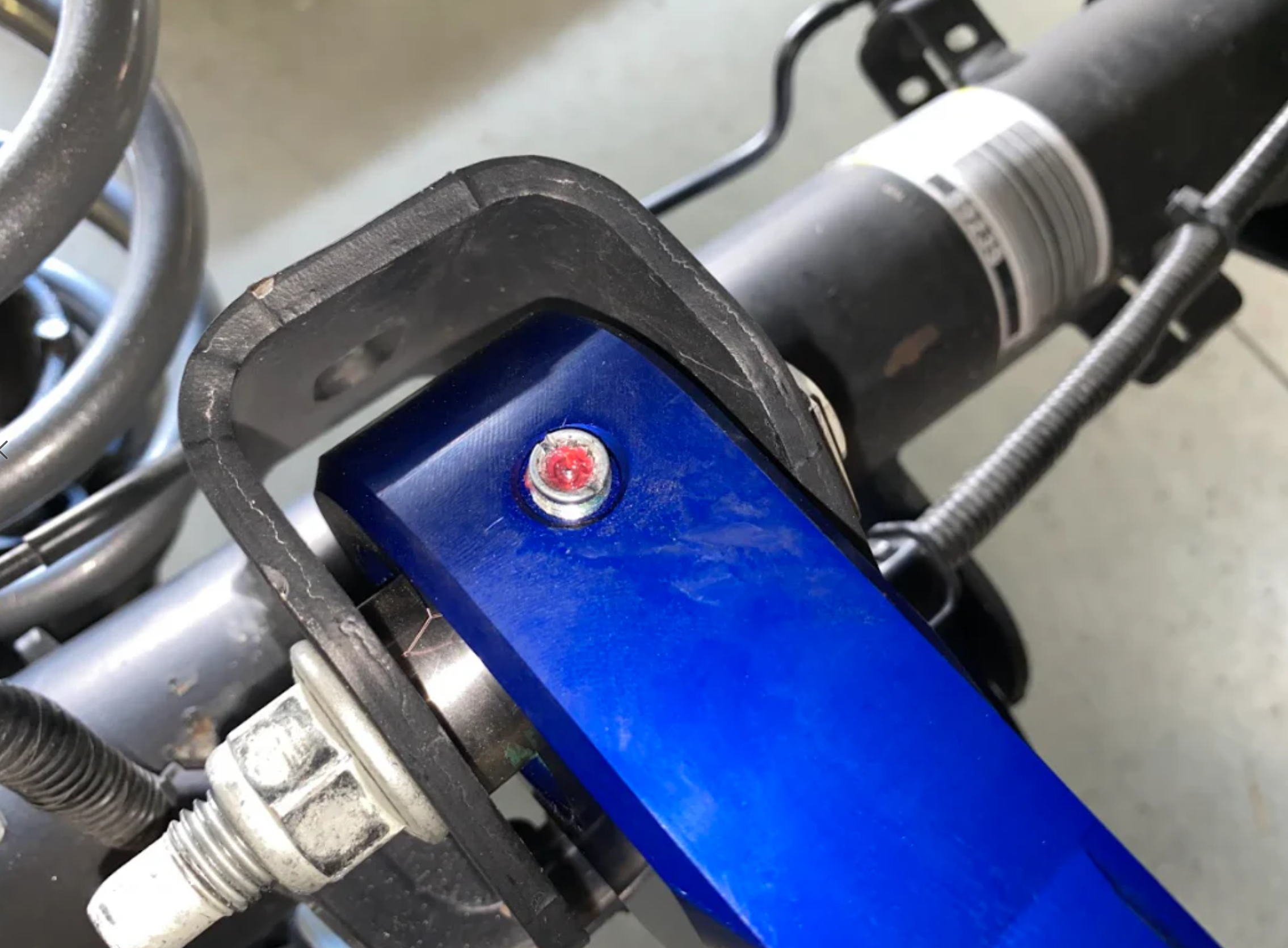 Close-up of a blue billet aluminum rear upper suspension arm for the 2024 Ranger Raptor, showcasing Ultra-Flex joints.
