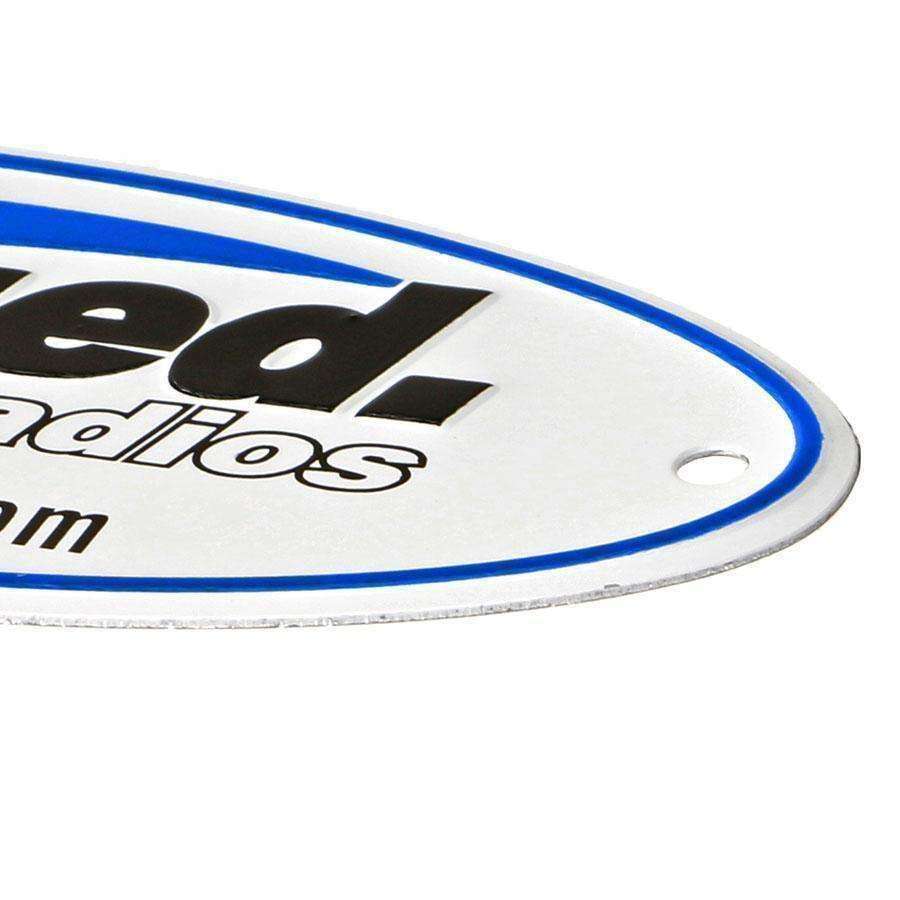 Metal Rugged Radios embossed badge featuring a sleek design with blue and black lettering for offroad enthusiasts.