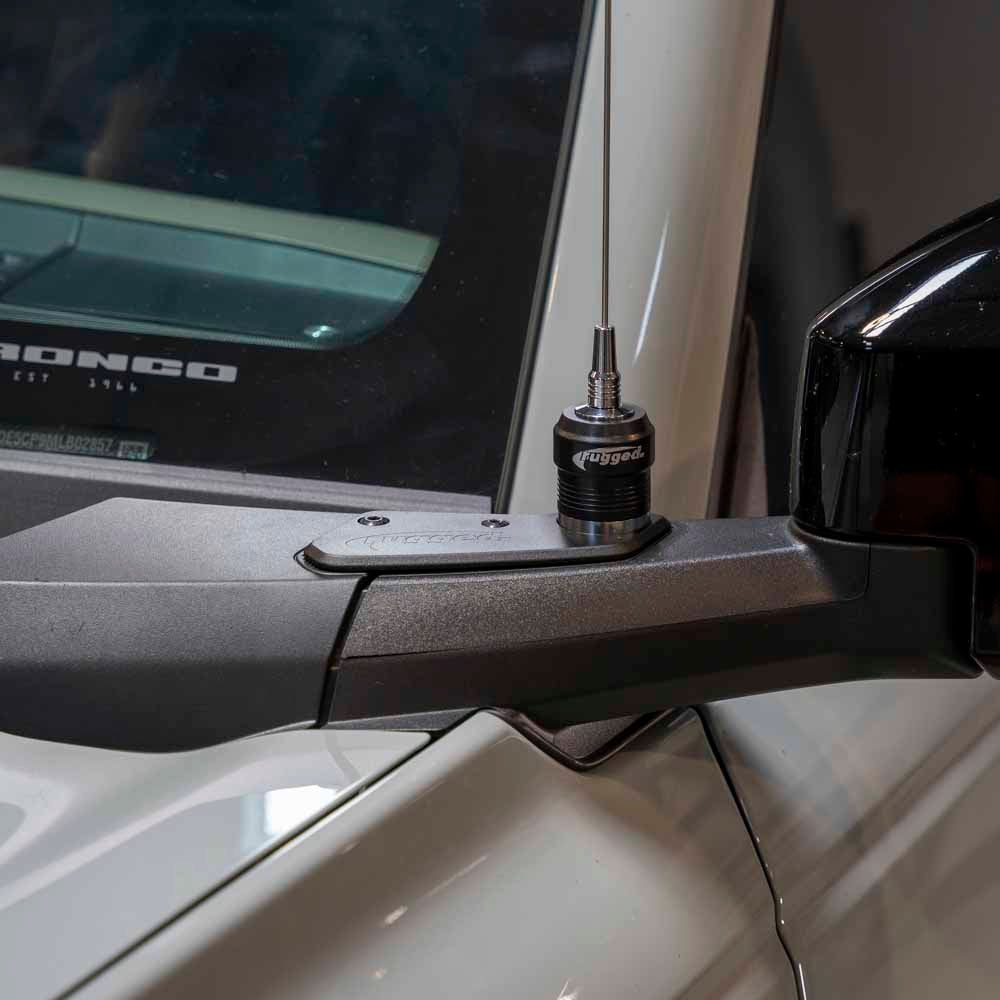 Antenna mount installed on the driver side view mirror of a new Ford Bronco, showcasing a sleek design and functionality.