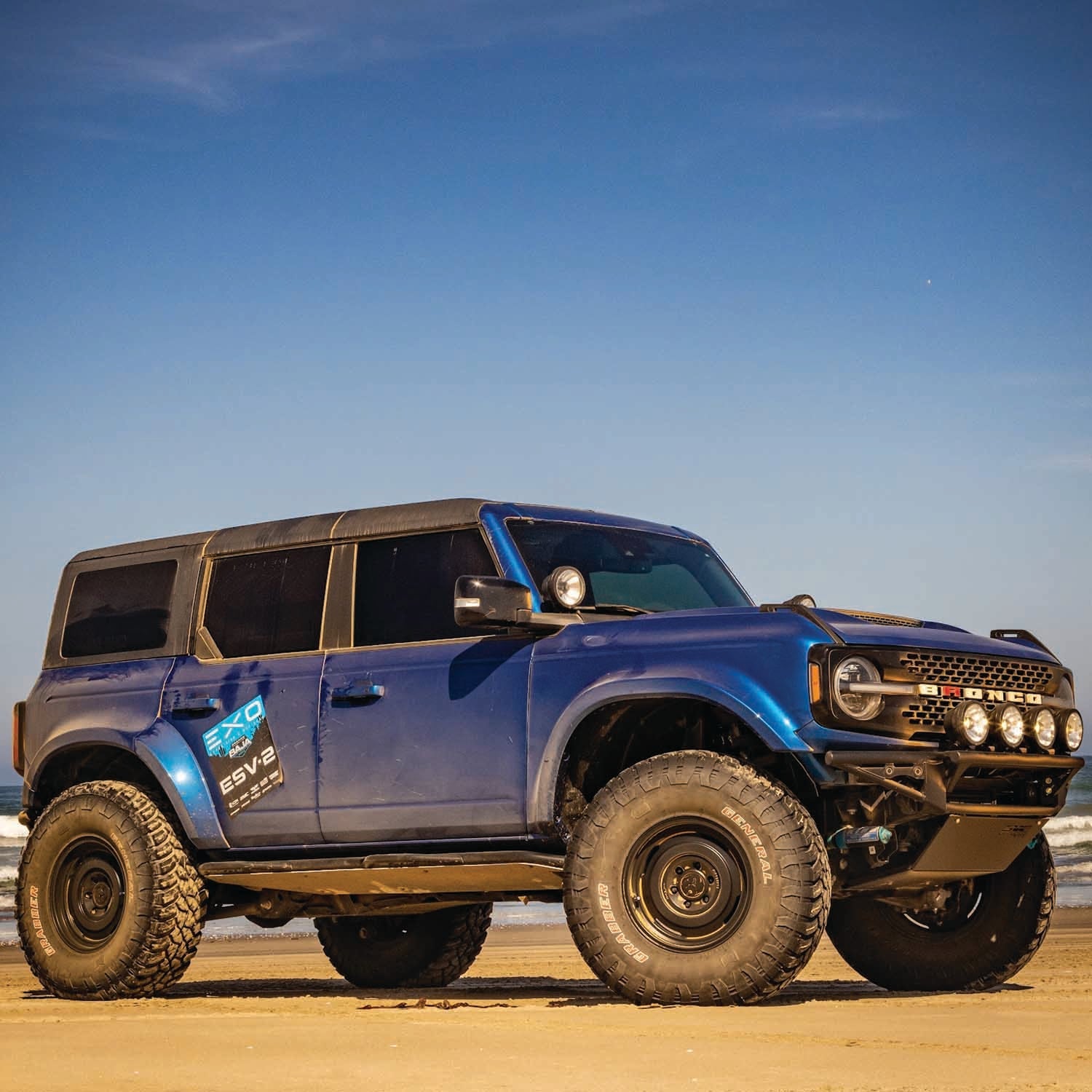 2021 Ford Bronco with Baja bumper, offroad-ready design, showcasing rugged features on a beach setting.