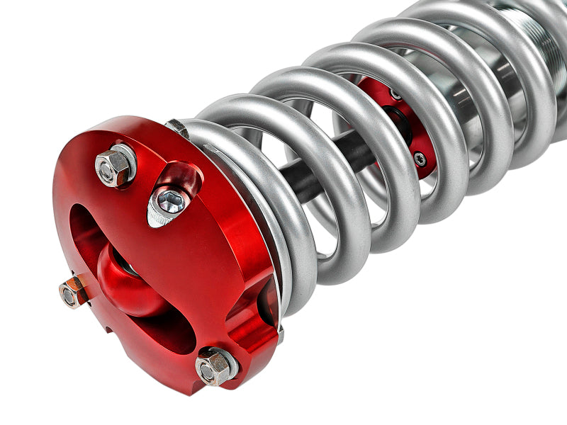 aFe Sway-A-Way 2.5in Front Coil Over Kit for 04-15 Nissan Titan featuring a silver coil spring and red top mount.