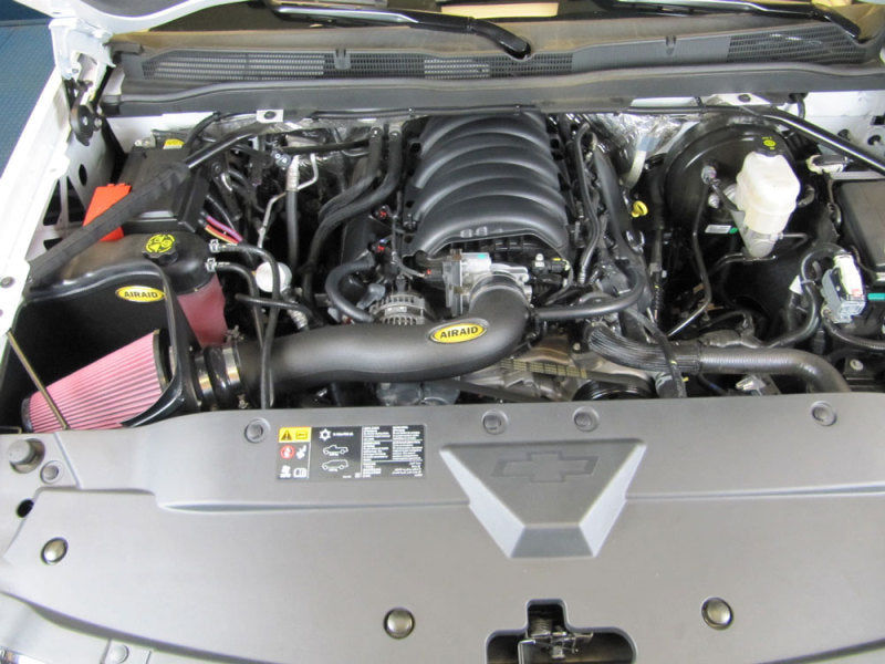 Airaid MXP intake system installed in a 2014 GM 1500 pickup engine bay, featuring a red filter and black intake tube.