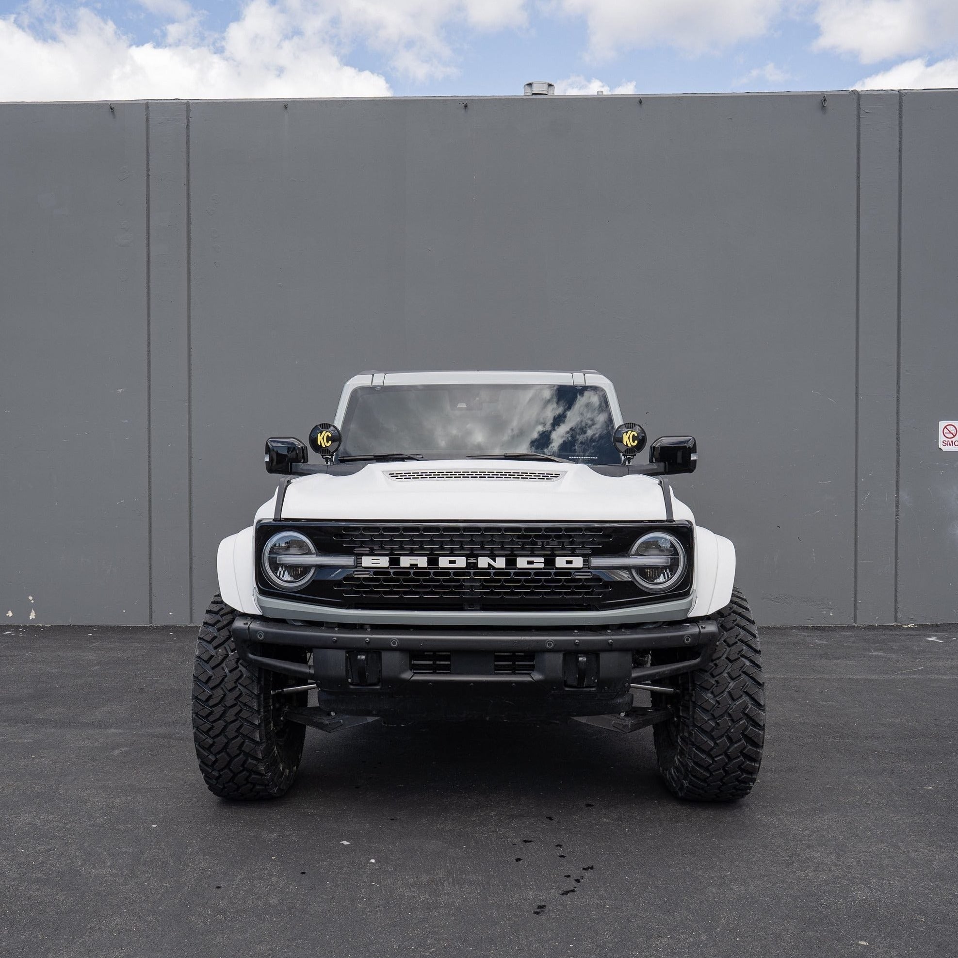 2021-2024 Ford Bronco with custom fenders, showcasing rugged design and off-road capability in a parking lot setting.