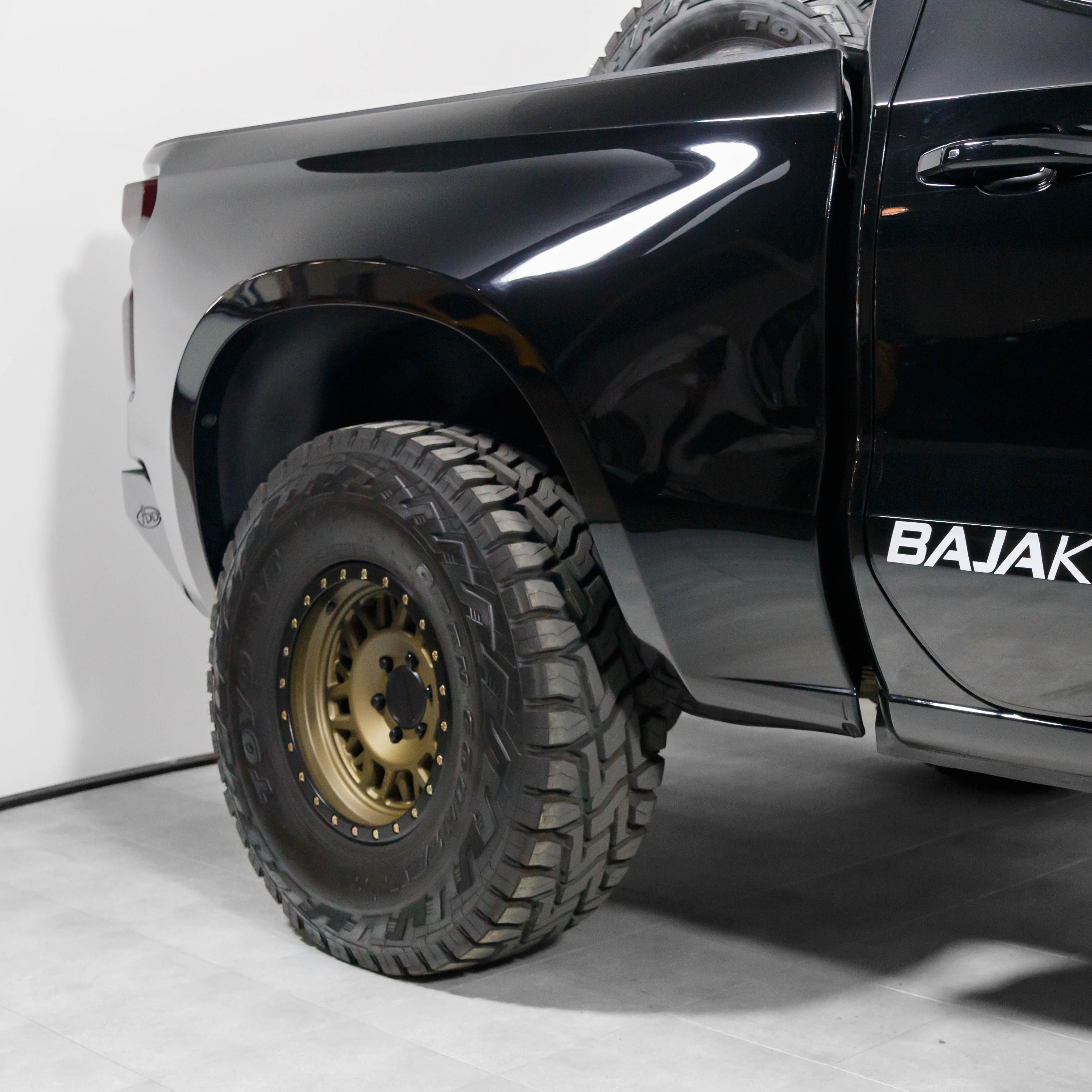 2019-2021 Chevrolet Silverado with aftermarket bedsides and rugged off-road tires, showcasing a sleek black finish.