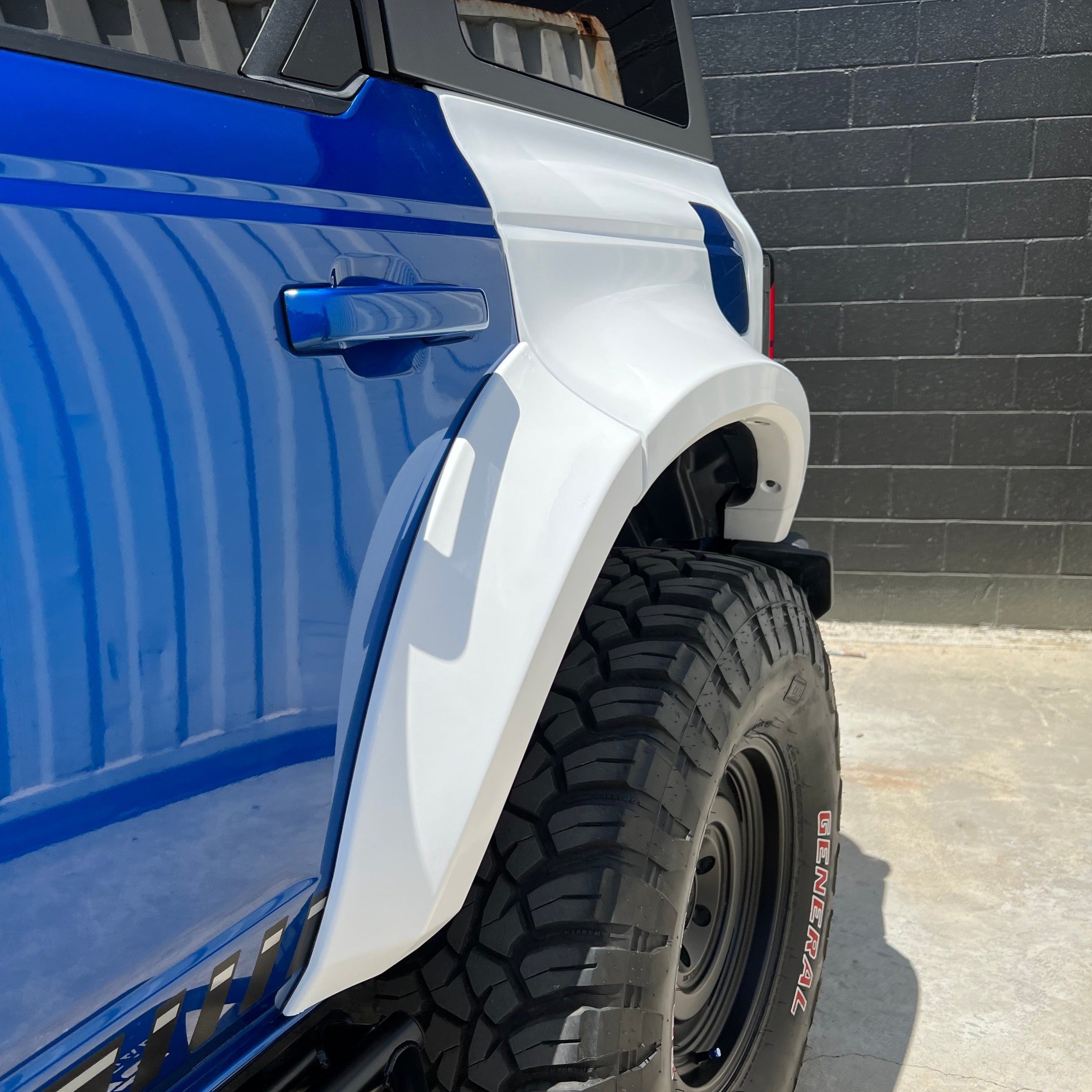 2021-2022 Ford Bronco 4-Door Rear Quarter Kit showcasing a blue vehicle with a white fender flare and rugged tire.