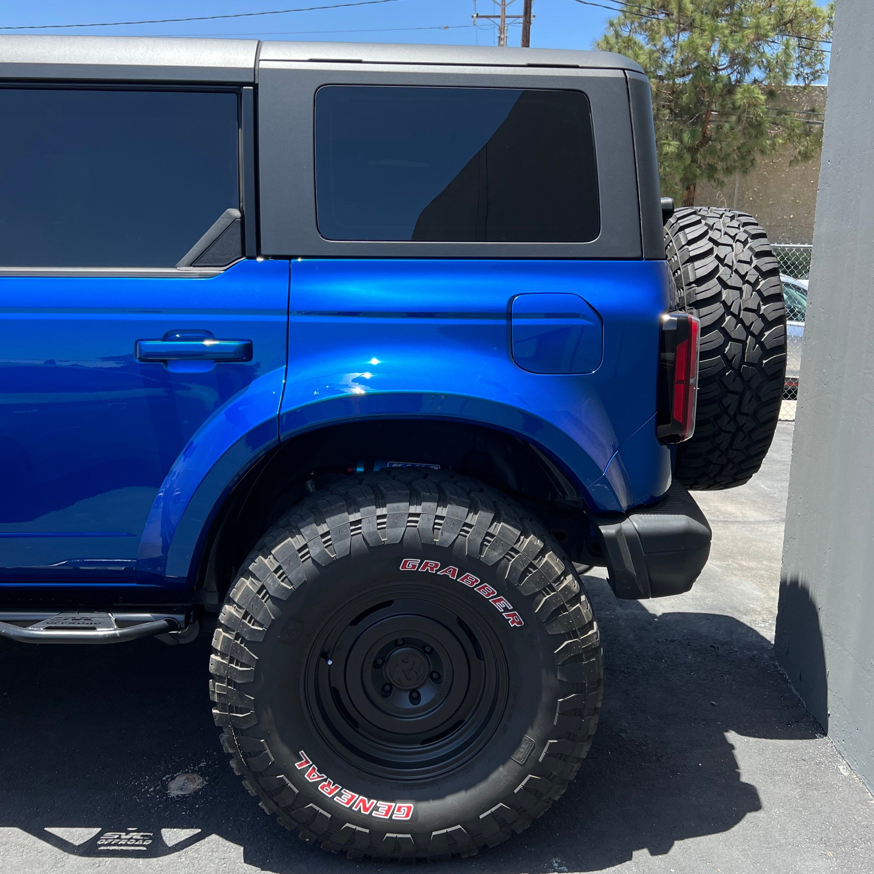 2021-2022 Ford Bronco 4-Door Rear Quarter Kit installed on a blue Bronco, showcasing rugged tires and sleek design.