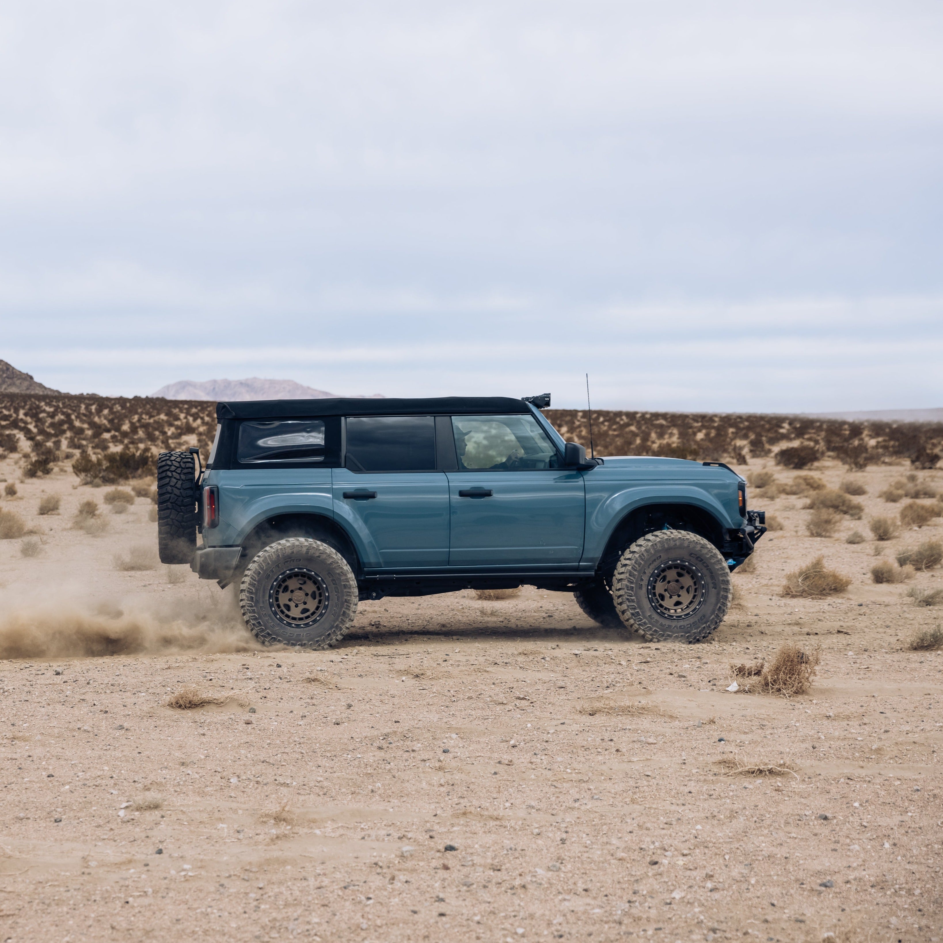 2021-2022 Ford Bronco 4-Door Rear Quarter Kit installed on a Bronco driving through a desert landscape.