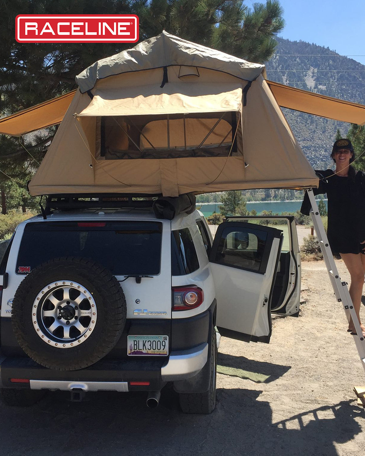 A rooftop tent setup on a vehicle, showcasing the 929M Avenger model, with a person standing beside it in a scenic outdoor location.