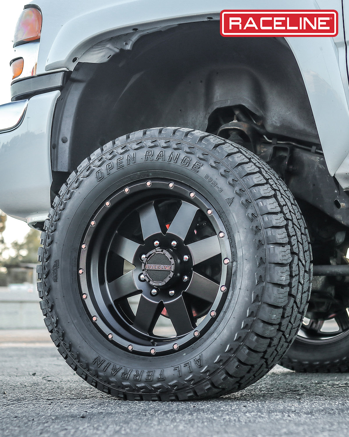 Black Raceline 935B Defender wheel with rugged tire mounted on a lifted truck, showcasing offroad capability and style.