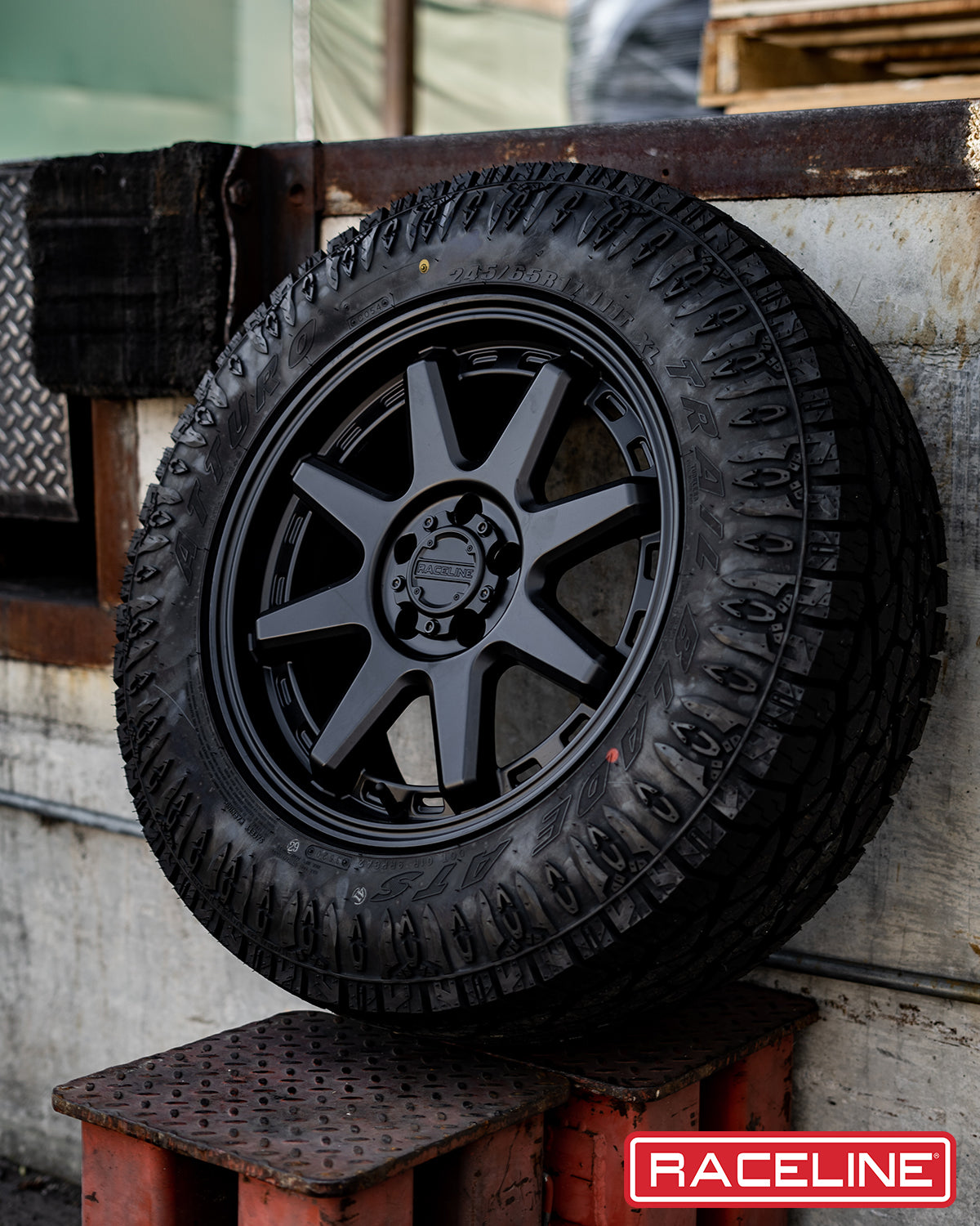 Black 947B Scout wheel mounted on an all-terrain tire, showcasing a rugged design ideal for offroad vehicles.