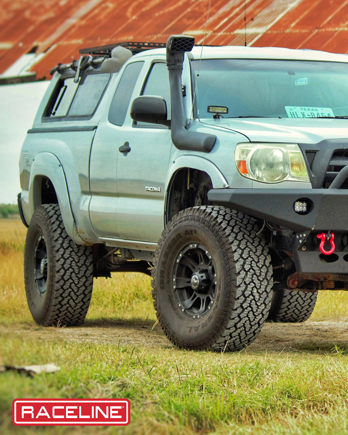 Black Raceline 981 Raptor wheels on a lifted Toyota Tacoma, showcasing an off-road setup with rugged tires.