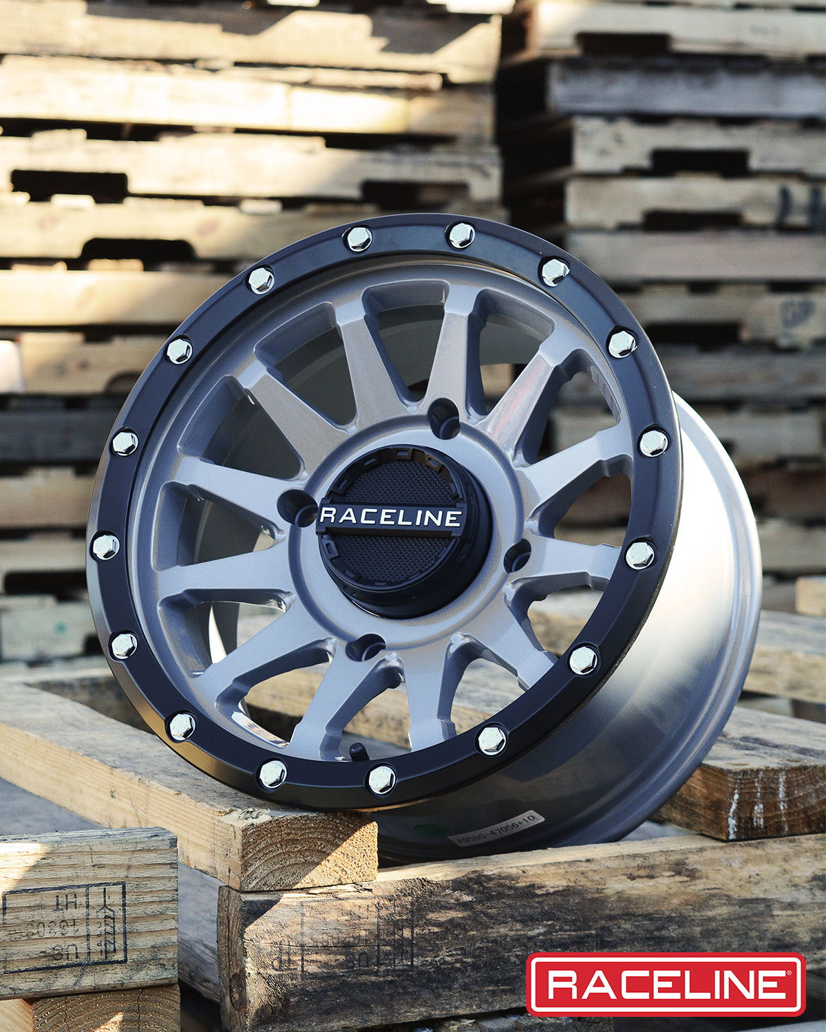 A95SG Trophy Simulated Beadlock wheel showcasing a sleek design with a black and silver finish, placed on wooden pallets.