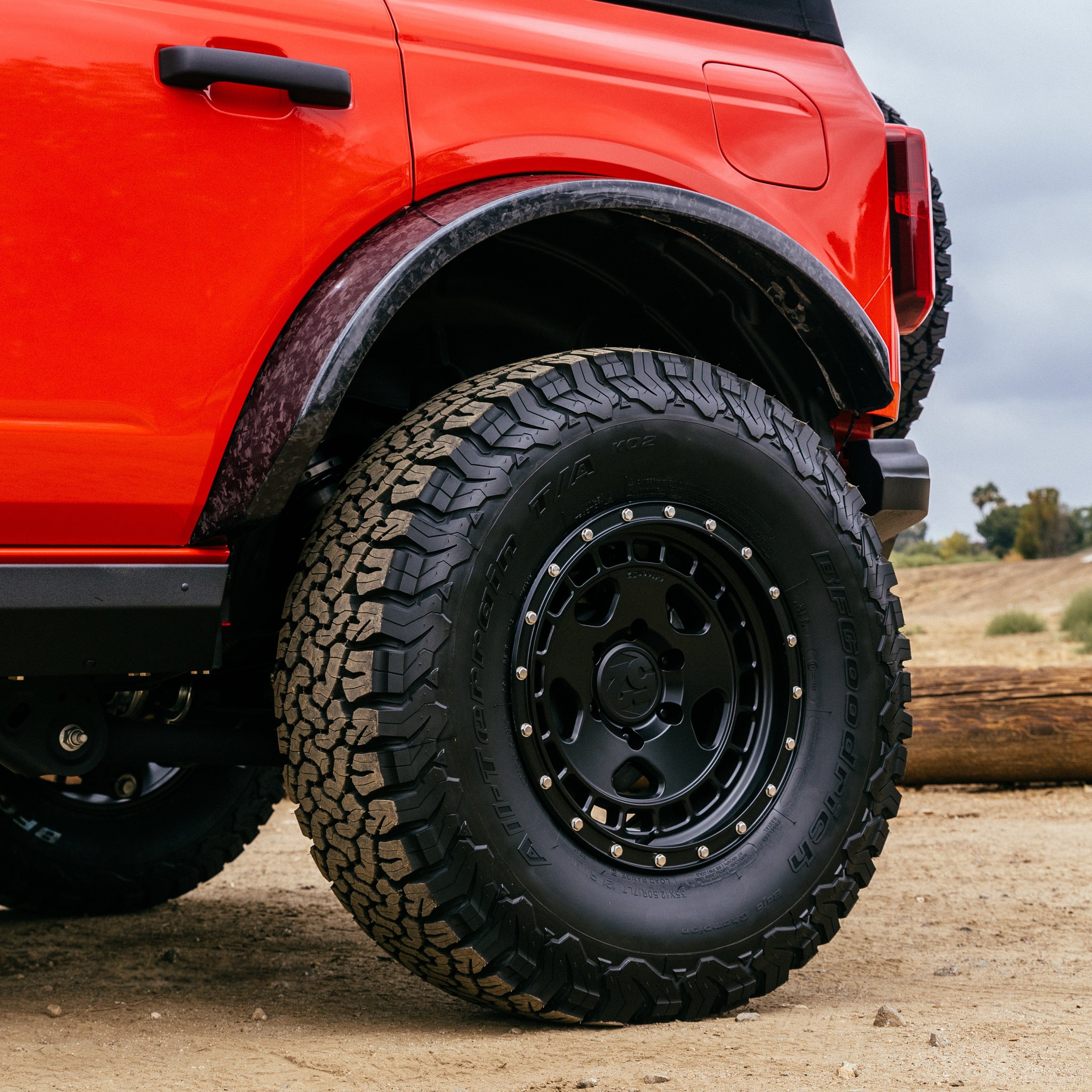 2021-2024 Ford Bronco Sasquatch Flares enhancing tire clearance and off-road capability on a rugged terrain vehicle.