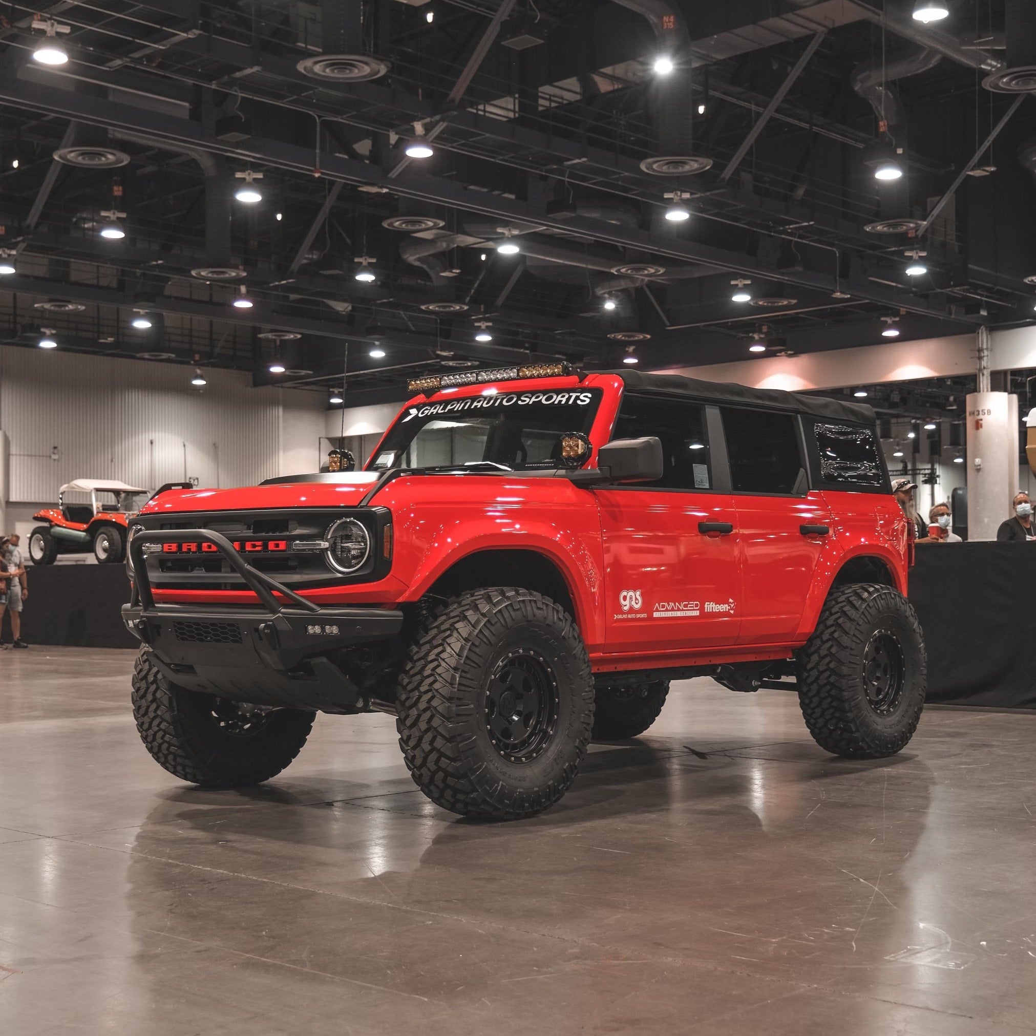 2021-2022 Ford Bronco 4-Door Rear Quarter Kit displayed on a modified red Bronco with offroad tires in an exhibition space.
